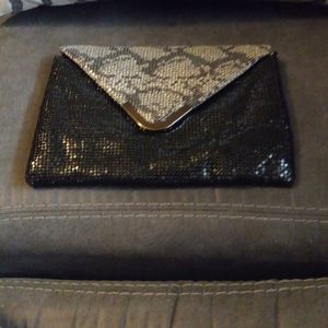 Medal chain meal envelope clutch with leopard print flap.